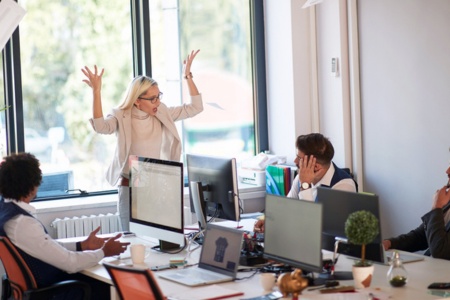 Boss throwing an employee's papers up into the air and yelling