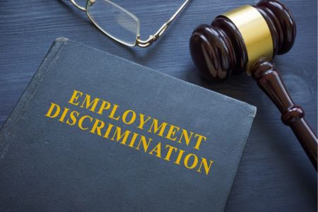 Employment discrimination book with gavel on desk.