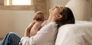 A woman holding a baby to her chest