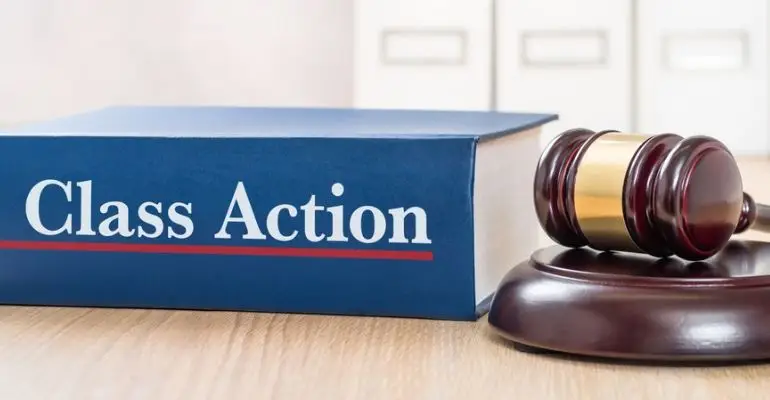 A book labeled Class Action sitting next to a gavel