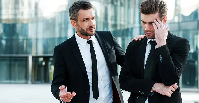 two men standing outside of office building concerned