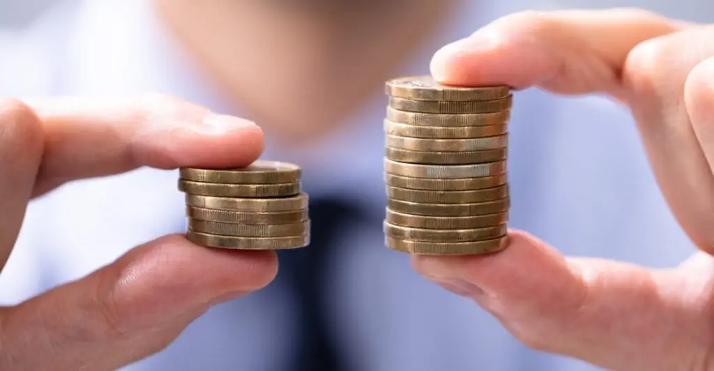 Person holding two unequal stacks of coins