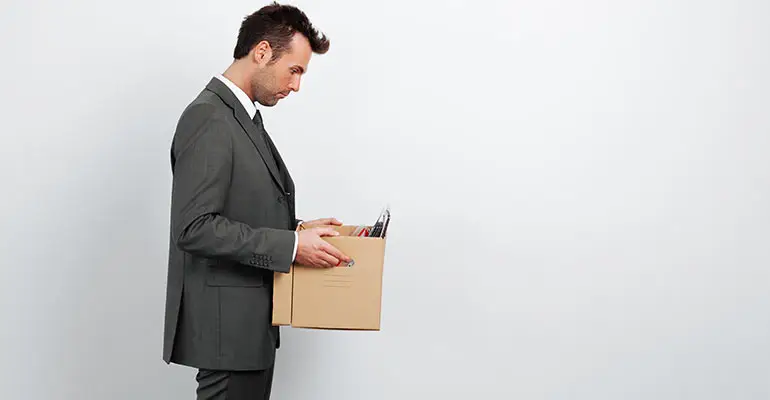 man holding box of belonging in an empty room